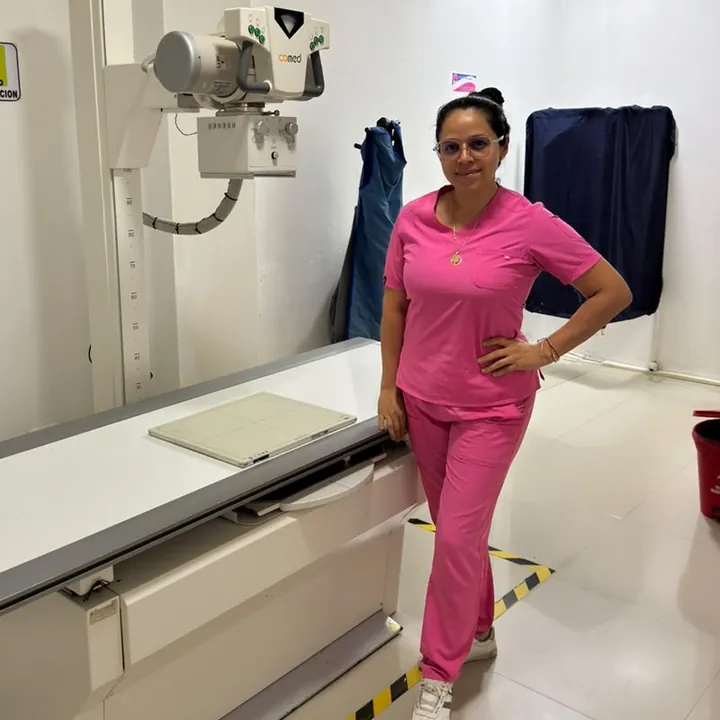 Profesional junto al equipo de rayos X en la sala de imágenes diagnósticas.